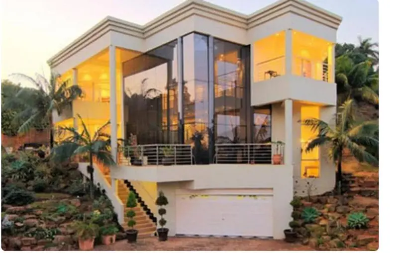 Bâtiment moderne avec de grandes baies vitrées et un jardin tropical.