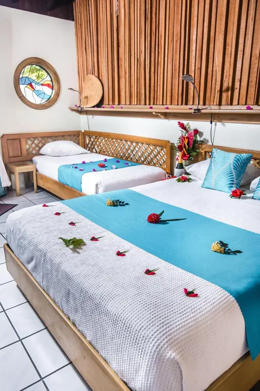 Chambre avec deux lits simples décorés de fleurs.