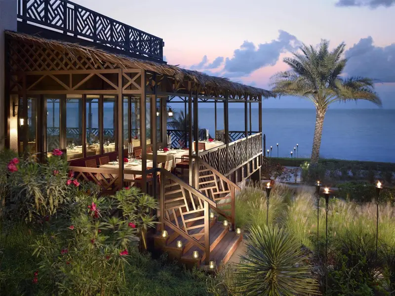 Terrasse de restaurant en bord de mer au coucher du soleil.