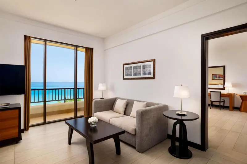 Un salon lumineux s'ouvre sur une vue mer par de grandes baies vitrées.