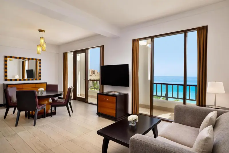 Espace de vie lumineux avec coin repas et vue sur la mer.