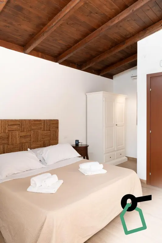 Une chambre lumineuse avec un lit fait et une armoire.
