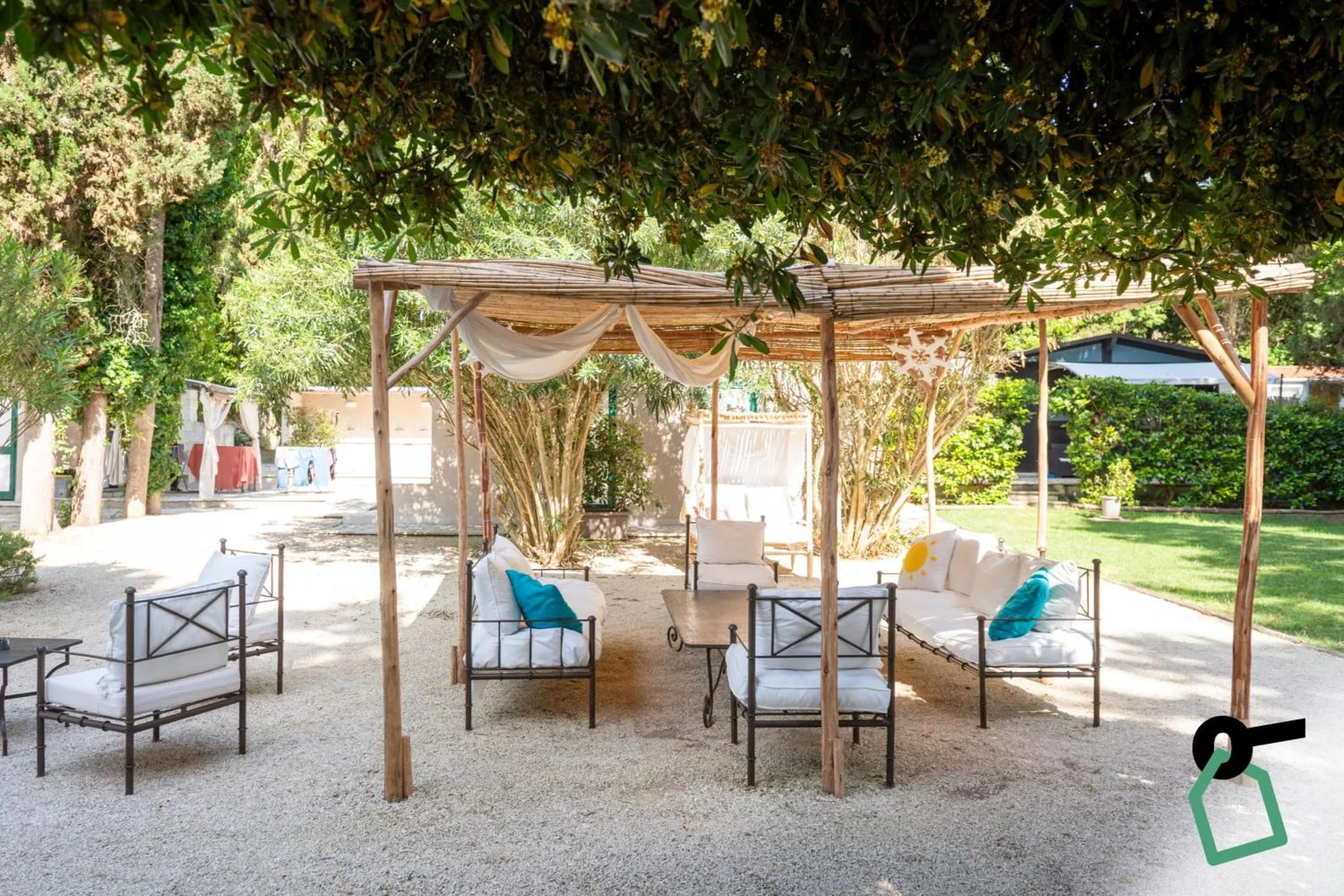 Espace de détente extérieur avec mobilier de jardin et pergola ombragée.