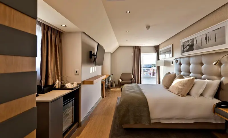 Une chambre spacieuse avec un grand lit et un coin salon.