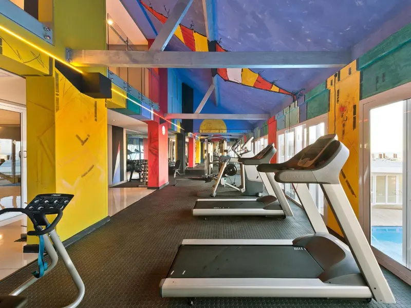 Une salle de sport lumineuse avec des équipements de cardio.