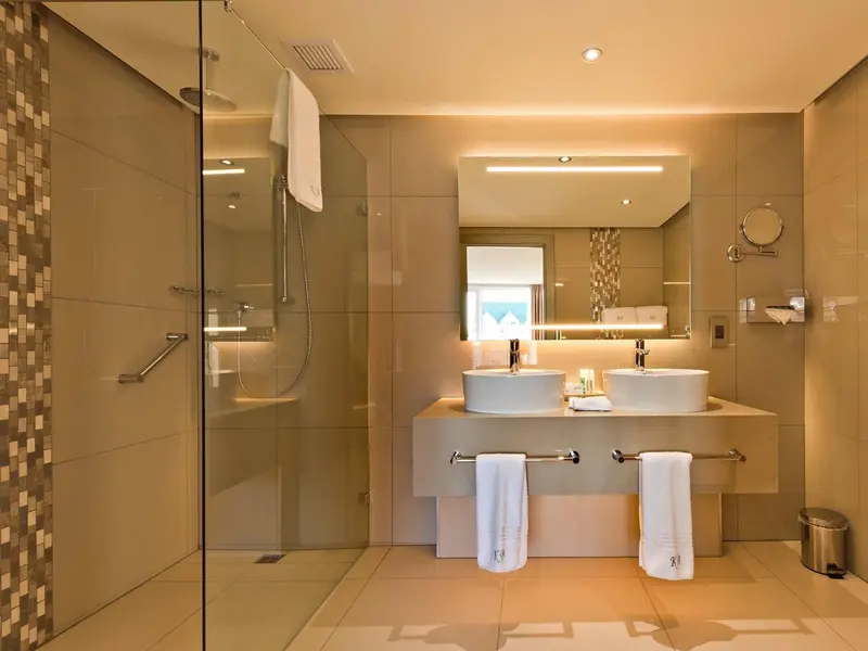 Une salle de bain moderne avec une douche à l'italienne et deux vasques.