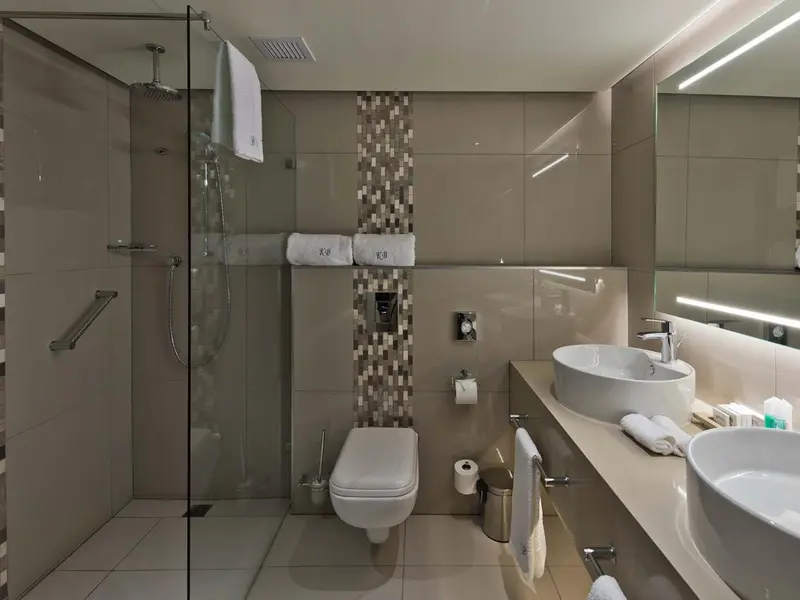 Une salle de bain moderne avec douche à l'italienne et lavabo double.