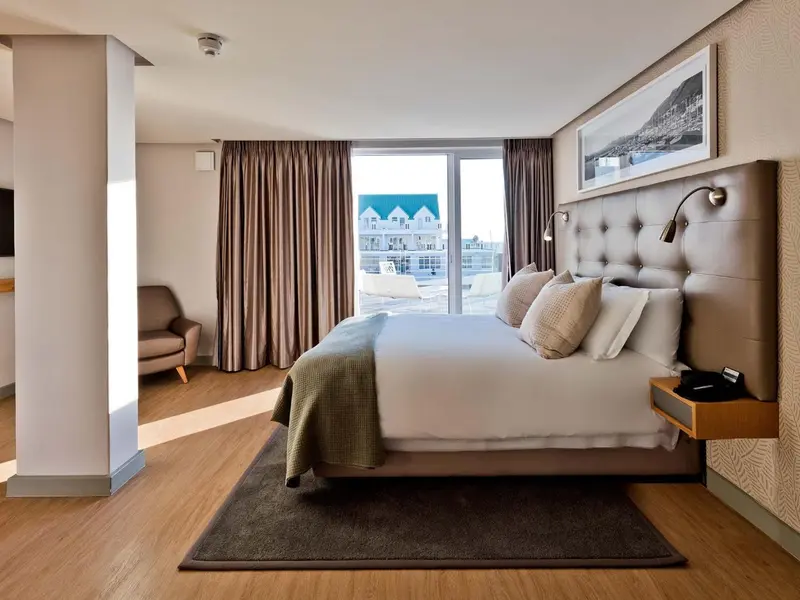 Une chambre spacieuse avec un grand lit et une vue sur la ville.