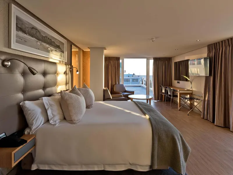 Une chambre lumineuse avec un grand lit et un accès à une terrasse.