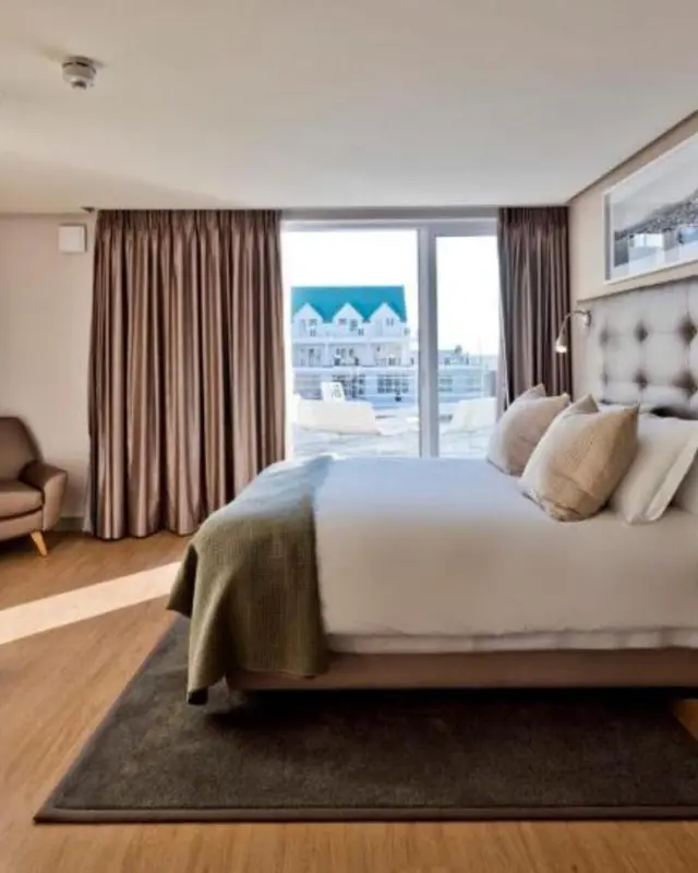 Une chambre lumineuse avec un grand lit et un accès à une terrasse.