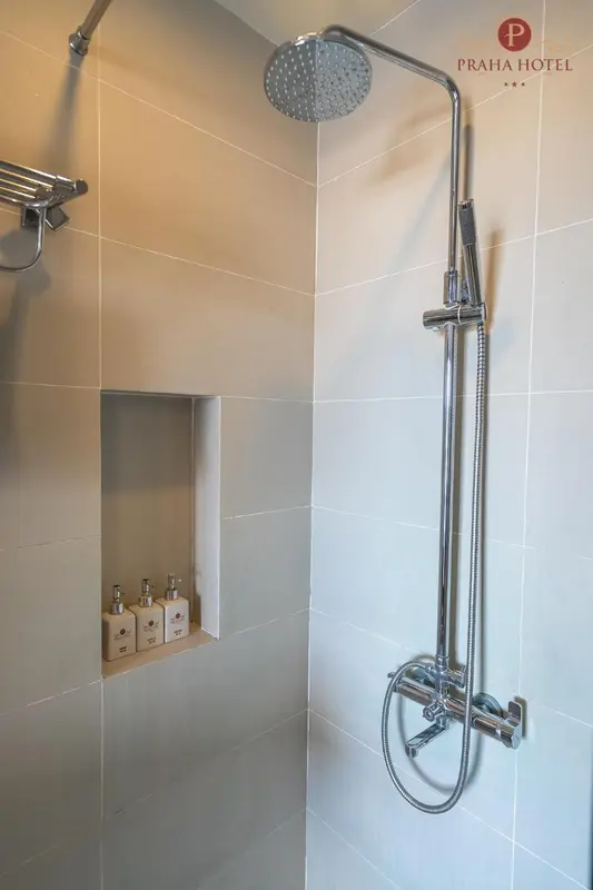 Douche à l'italienne avec pommeau et mitigeur chromés.