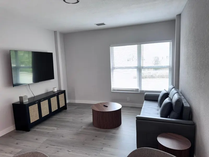 Un espace de vie moderne avec un canapé, une table basse et un téléviseur mural.