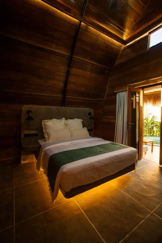 Une chambre lumineuse avec un grand lit et une décoration en bois.
