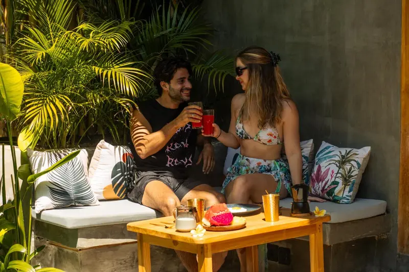 Un couple souriant partage un moment de détente sur une banquette extérieure.
