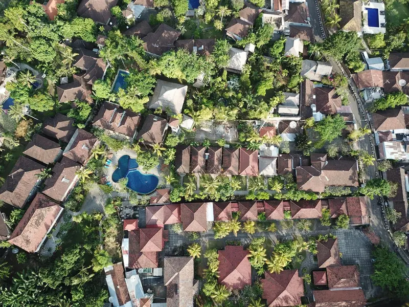Vue aérienne d'un complexe hôtelier tropical avec des bâtiments aux toits rouges et une végétation luxuriante.