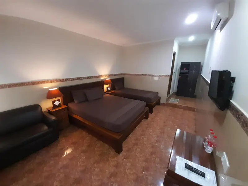 Une chambre avec un grand lit et un coin salon.