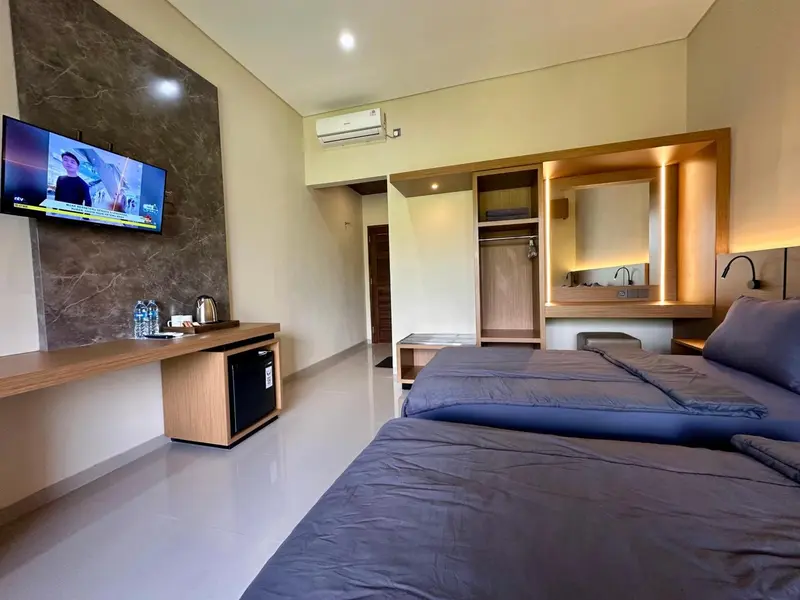 Une chambre moderne avec un grand lit et un téléviseur mural.