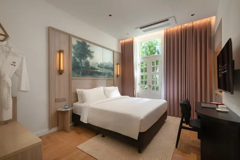 Une chambre lumineuse avec un grand lit et un bureau.