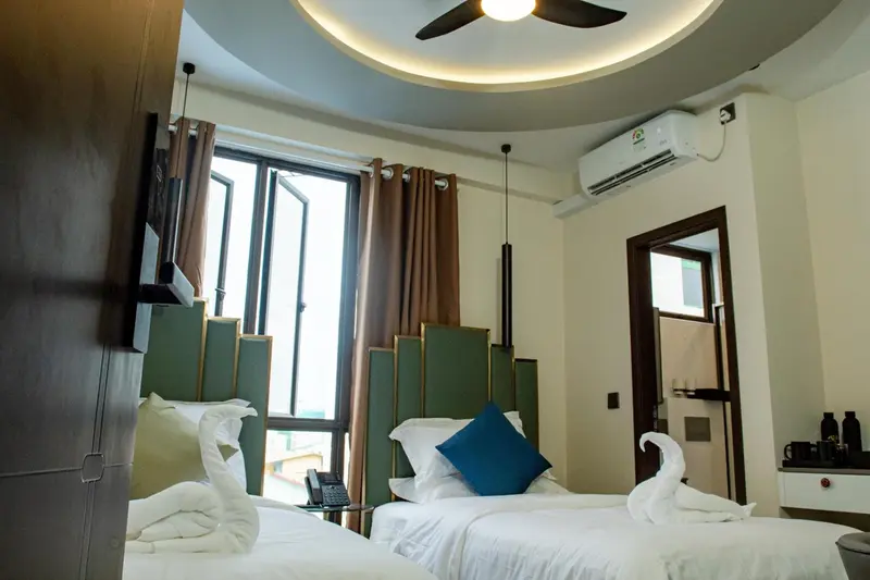 Une chambre lumineuse avec deux lits simples et une décoration soignée.