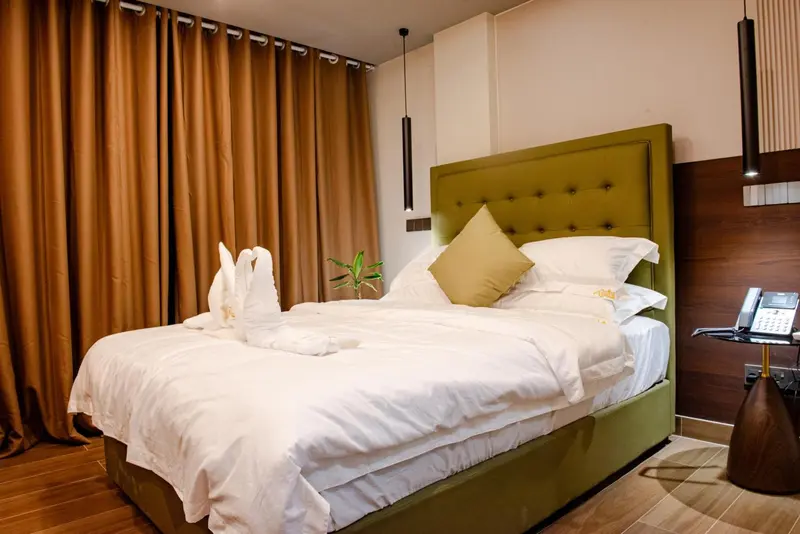 Une chambre avec un grand lit recouvert de draps blancs et de coussins.