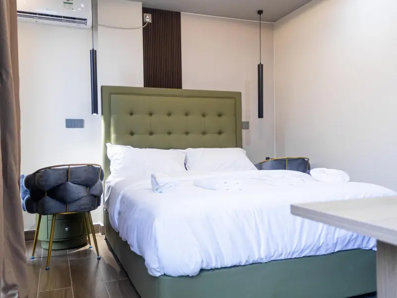 Une chambre lumineuse avec un grand lit recouvert de draps blancs.