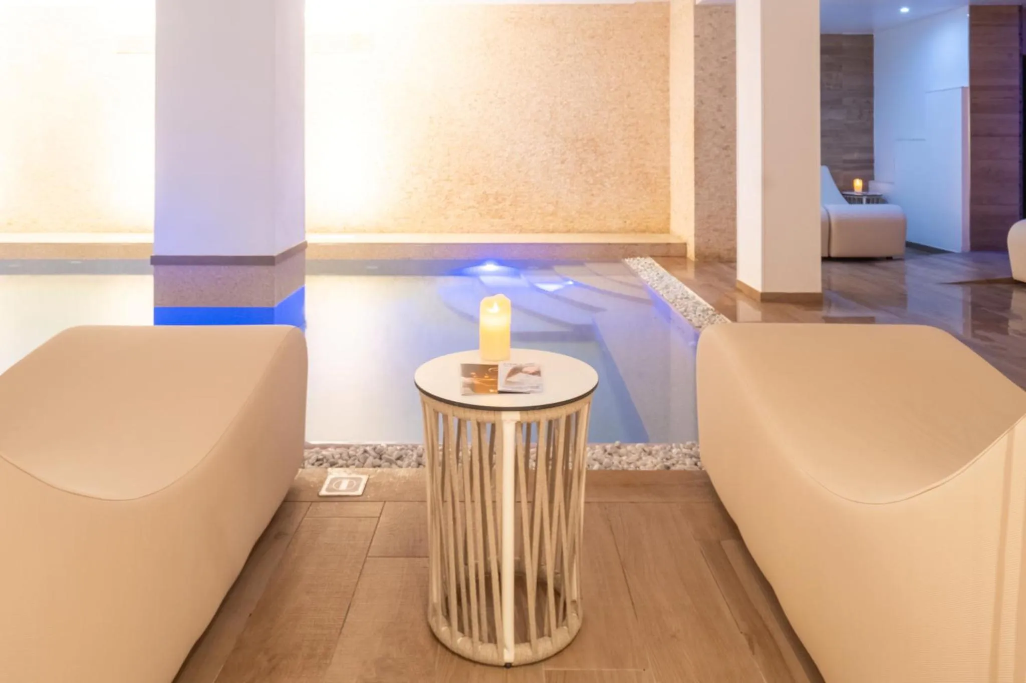 Espace de détente avec des fauteuils et une petite piscine intérieure.
