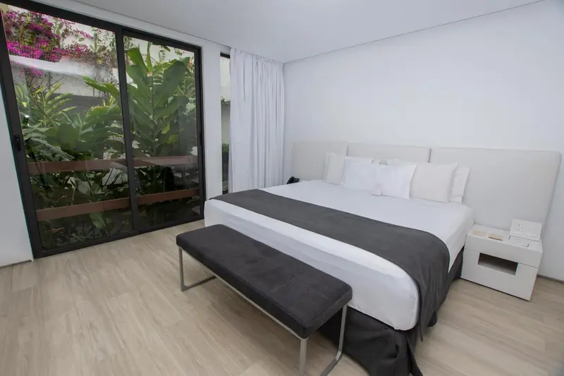 Une chambre moderne avec un grand lit et un accès à une terrasse.