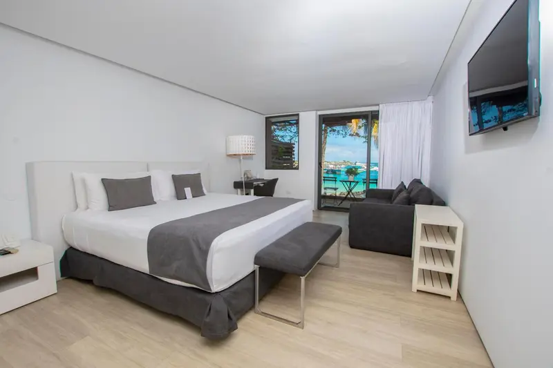 Une chambre lumineuse avec un grand lit et une vue sur la mer.