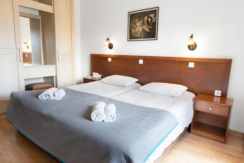 Une chambre lumineuse avec un grand lit et une décoration murale.