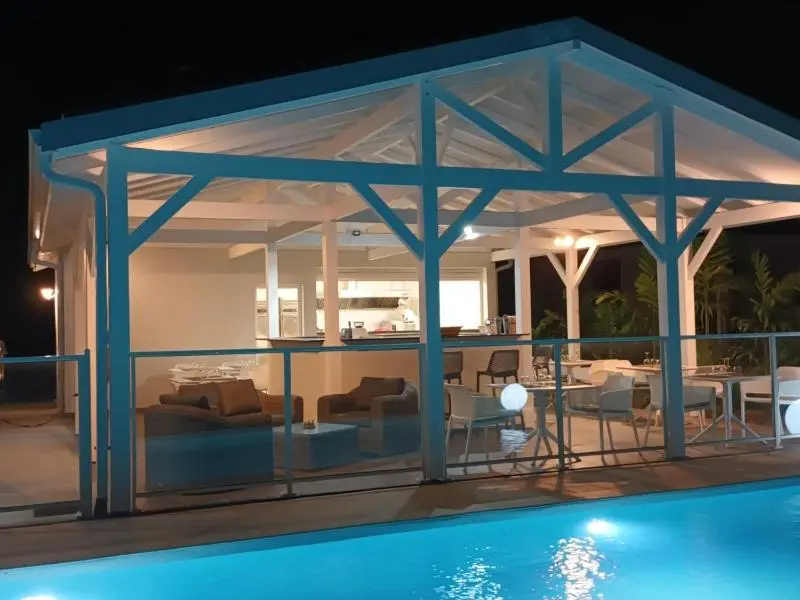 Terrasse lumineuse donnant sur un espace de vie et une piscine.