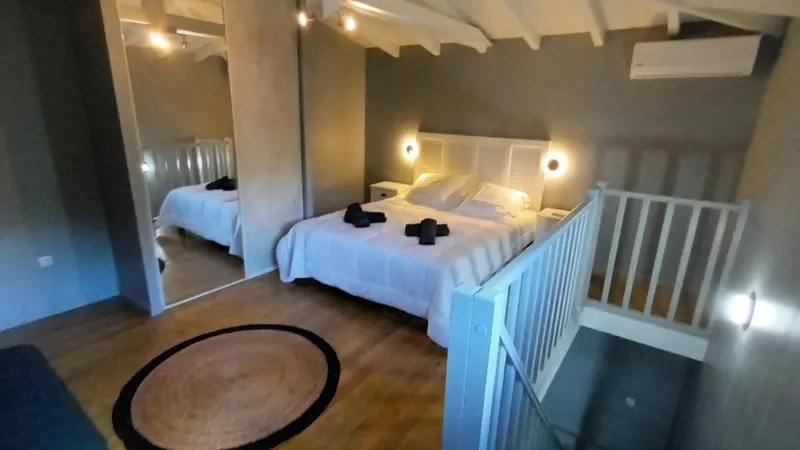 Une chambre lumineuse avec deux lits et un tapis rond.