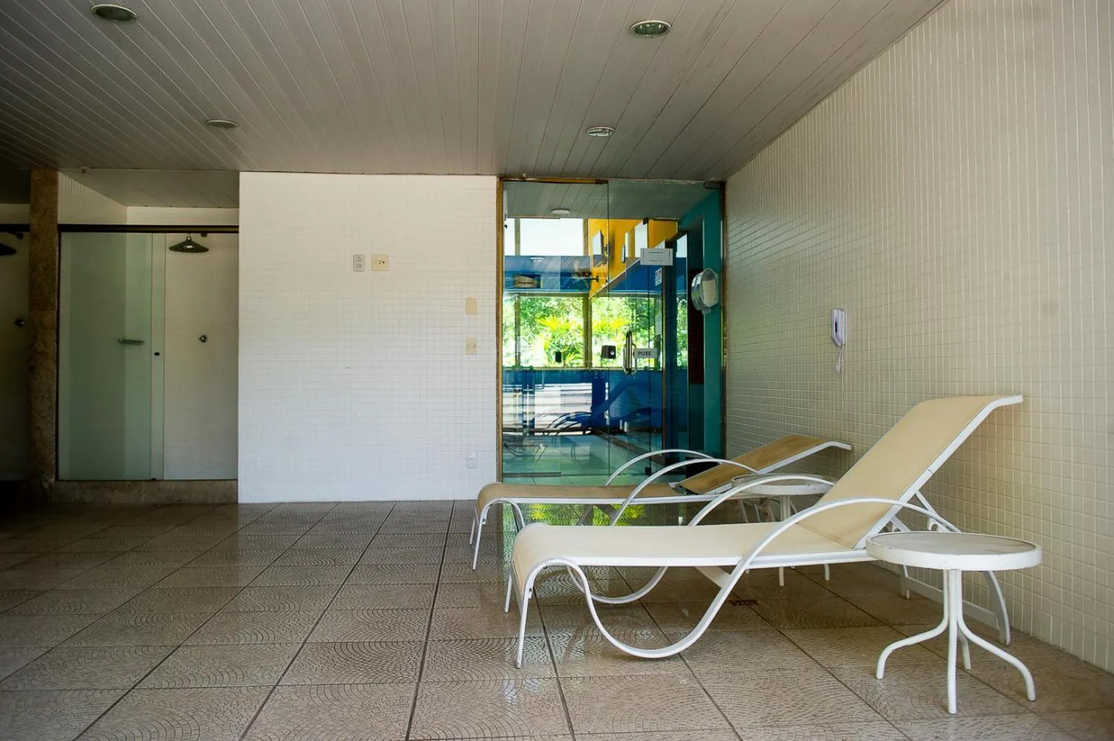 Espace de détente avec transats et accès à une piscine.