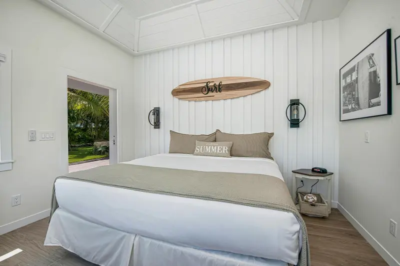 Une chambre lumineuse avec un grand lit et un décor marin.