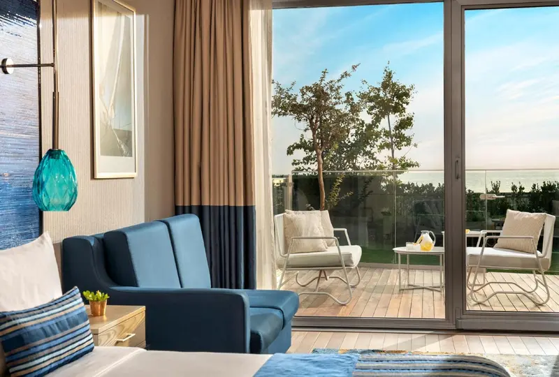 Une chambre s'ouvre sur une terrasse avec vue sur la mer.
