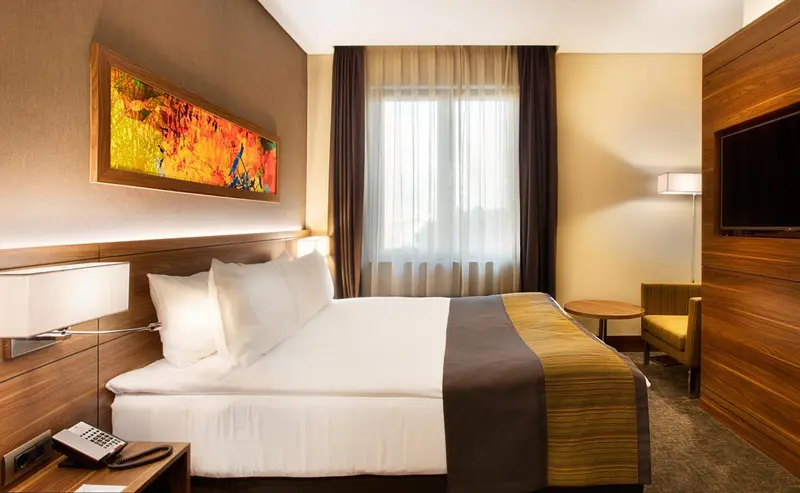 Une chambre d'hôtel moderne avec un grand lit et un éclairage tamisé.