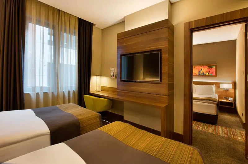 Une chambre d'hôtel moderne avec deux lits et un bureau.