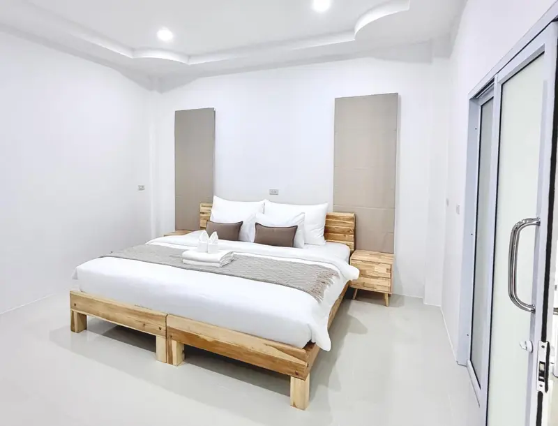 Une chambre lumineuse avec un grand lit et une décoration sobre.