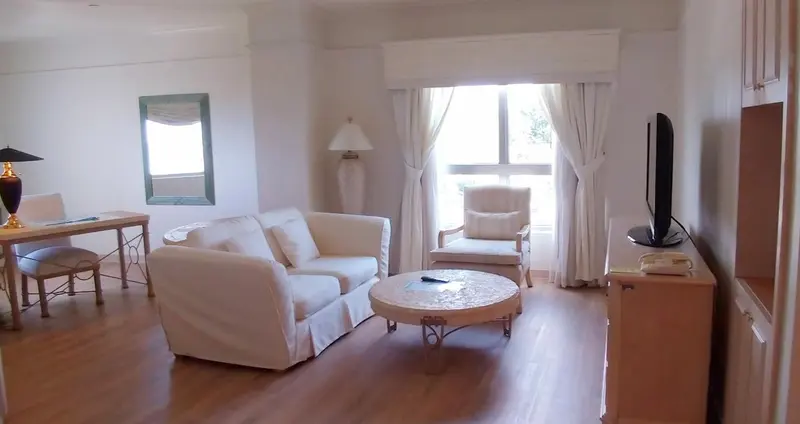 Espace de séjour clair avec canapés et fauteuils.
