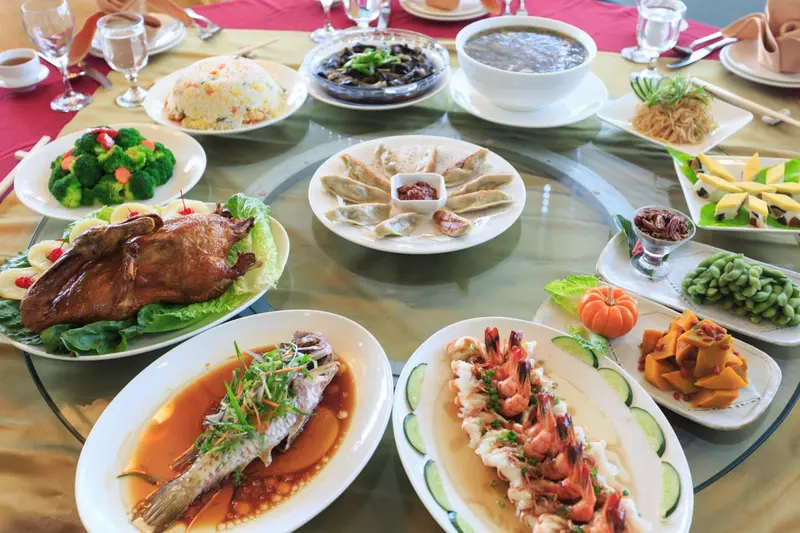 Une table ronde est dressée avec une variété de plats asiatiques.