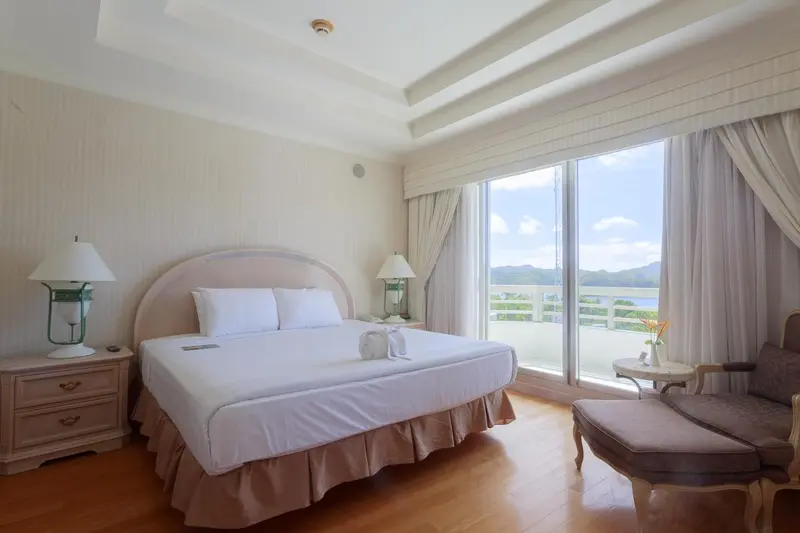 Une chambre lumineuse avec un grand lit et une vue sur la mer.