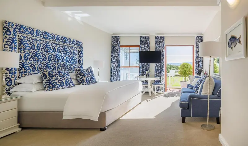 Une chambre lumineuse avec un grand lit et un coin salon.