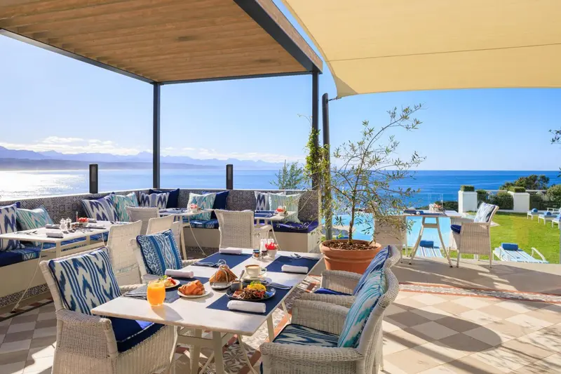 Tables dressées en terrasse avec vue sur la mer.