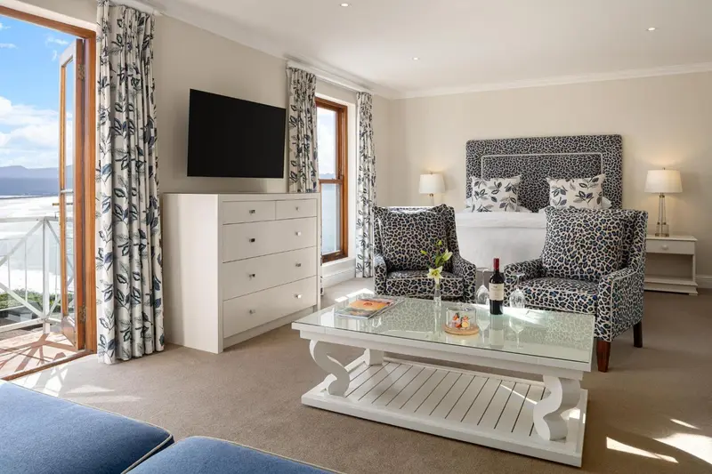Une chambre lumineuse avec un grand lit et un coin salon.