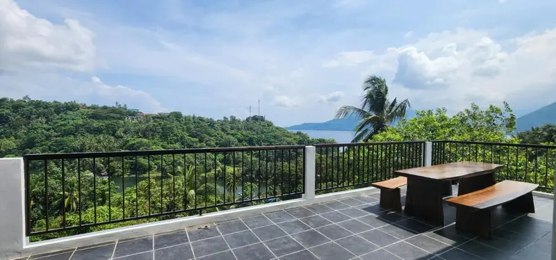 Terrasse avec mobilier en bois donnant sur une vue panoramique.