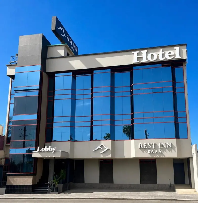 Façade moderne d'un bâtiment avec une entrée signalée par un auvent.