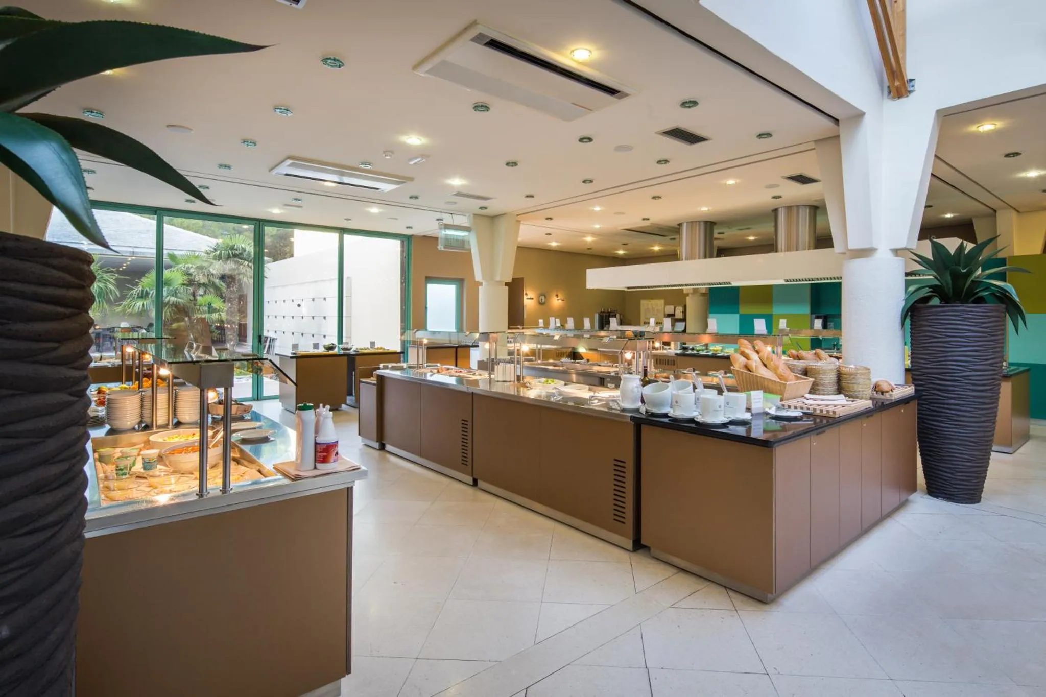 Un buffet propose une variété de plats et de boissons dans une salle lumineuse.