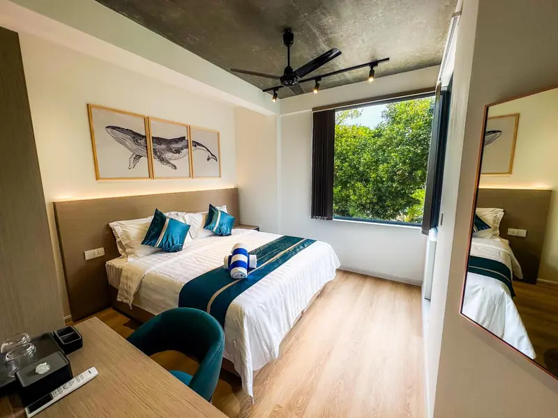 Une chambre lumineuse avec un grand lit et des illustrations murales.