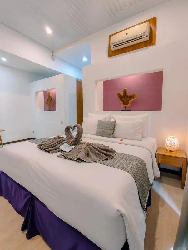 Une chambre lumineuse avec un lit soigneusement fait et une décoration florale.