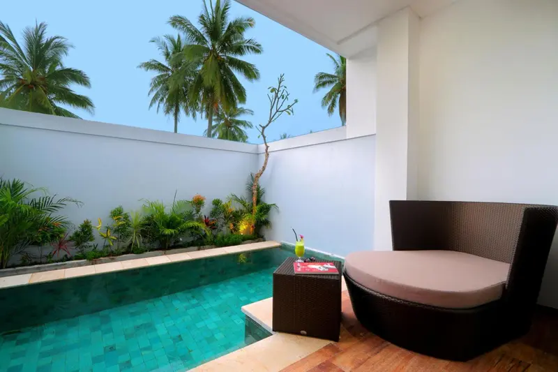 Petite piscine turquoise et mobilier de détente sur une terrasse.