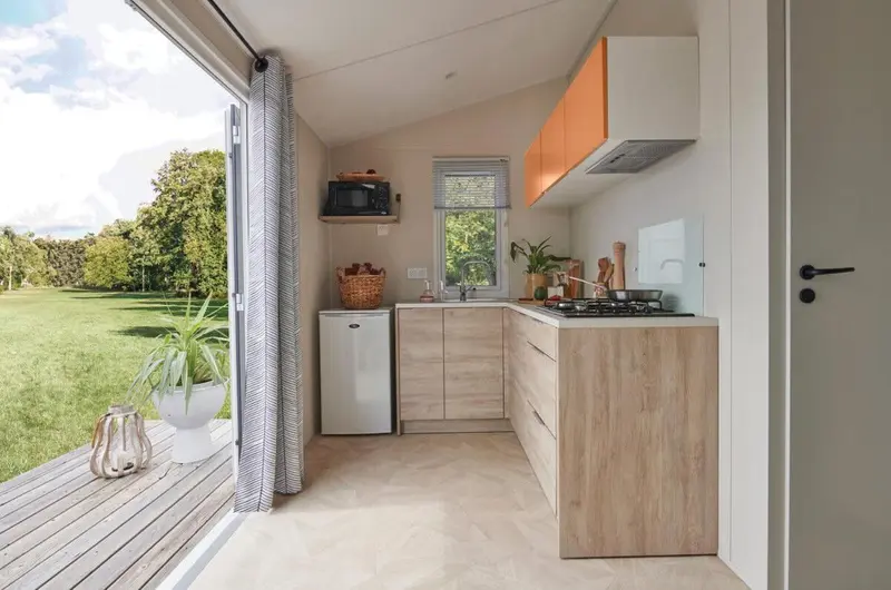 Une cuisine ouverte sur une terrasse avec vue sur un jardin.